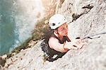 Focused, determined female rock climber scaling rock