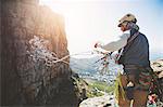 Male rock climber throwing rope