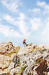 Rock climber reaching top of rocks