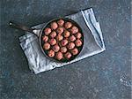 Homemade roasted beef meatballs in cast-iron skillet on dark blue background. Top view or flat-lay. Copy space for text.