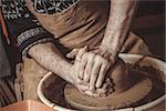 Adult male potter master mashing the clay.