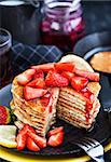 Stack of freshly prepared lemon poppy seed  pancakes with fresh strawberry and syrup for breakfast