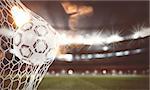 Soccer ball pierces the soccer goal at the stadium during a night match. 3D Rendering