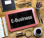 Small Chalkboard with E-Business Concept. Top View of Office Desk with Stationery and Red Small Chalkboard with Business Concept - E-Business. 3d Rendering.