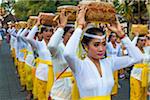 Procession of rows of Balinese women carrying offerings over their heads in the Ngrupuk Parade on the eve of Nyepi Day in Ubud in Gianyar, Bali, Indonesia