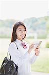 Cute Japanese high school student in a city park