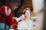 Bride preparing for wedding with make-up artist