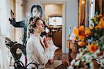 Bride preparing for wedding with hairstylist