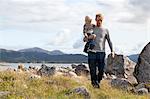 Man carrying son by fjord, Aure, More og Romsdal, Norway