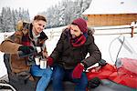 Young men having coffee outdoors in winter