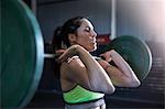 Woman exercising in gym, using barbell