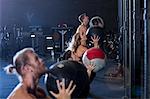 Group of people exercising in gym, using medicine balls