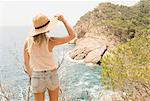 Woman along coastline, looking at view, rear view, Tossa de mar, Catalonia, Spain