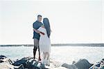 Couple standing on coastal rock, face to face, Seal Beach, California, USA