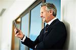 Senior businessman looking at smartphone in office