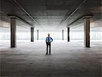 Asian businessman in a new empty raw office space.