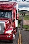 Close up view of the cab and driver of a  commercial truck on the highway.