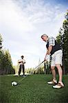 Senior golfer teeing off during a round of golf.