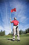 A senior golfer ready to approach the next shot on a golf course.