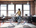 Hispanic man at his office workstation with a bicycle.