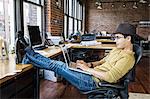 Hispanic man working on his laptop computer at this creative office work station.