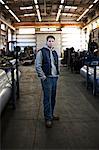 Young Caucasian man factory worker standing in a sheet metal factory.