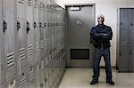 Black man factory worker standing next to lockers in a factory break room.