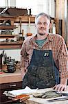 Caucasian man factory worker at a work station in a woodworking factory.