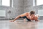 Athletic young man doing push ups on the floor. Young man workout in fitness club.