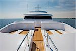 View over the bow of a large luxury motor yacht on tropical open ocean with bridge