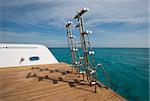 Metal steel ladders on back teak deck of a luxury motor yacht sailing on a tropical ocean