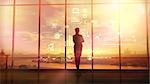 Silhouette of a woman in a huge office in front of large windows viewing corporate infographics.