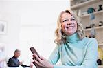 Smiling, confident mature woman using smart phone