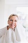 Smiling mature woman drying face with towel