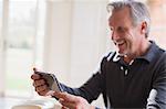 Smiling mature man using smart phone