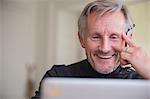 Smiling mature male freelancer working at laptop