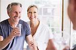 Smiling mature couple at bathroom mirror