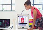 Female designer watching 3D printer