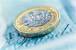 Close up one pound coin on five pound note