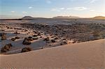 The dramatic Dunas de Corralejo in evening light on the volcanic island of Fuerteventura with mountains beyond, Fuerteventura, Canary Islands, Spain, Atlantic, Europe