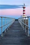 The south jetty and harbour light at sunset in winter, Amble, Northumberland, England, United Kingdom, Europe
