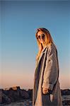 Portrait of woman wearing sunglasses and winter coat looking at camera smiling, side view, Odessa, Odeska Oblast, Ukraine, Eastern Europe