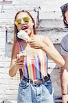 Young women eating melting ice cream cone