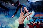 Couple practising acroyoga on outdoor stage