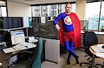 Caucasian middle aged man super hero in his cubicle office.