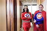 Super hero office team made up of a black woman and a middle aged Caucasian man.