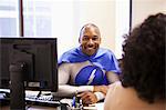 A black businessman office super hero in a meeting with an office team member.