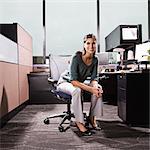 Hispanic woman in an office cubicle.