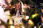 Close up of star shaped glass ornament on Christmas Tree.