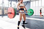 Woman weightlifting barbell in gym